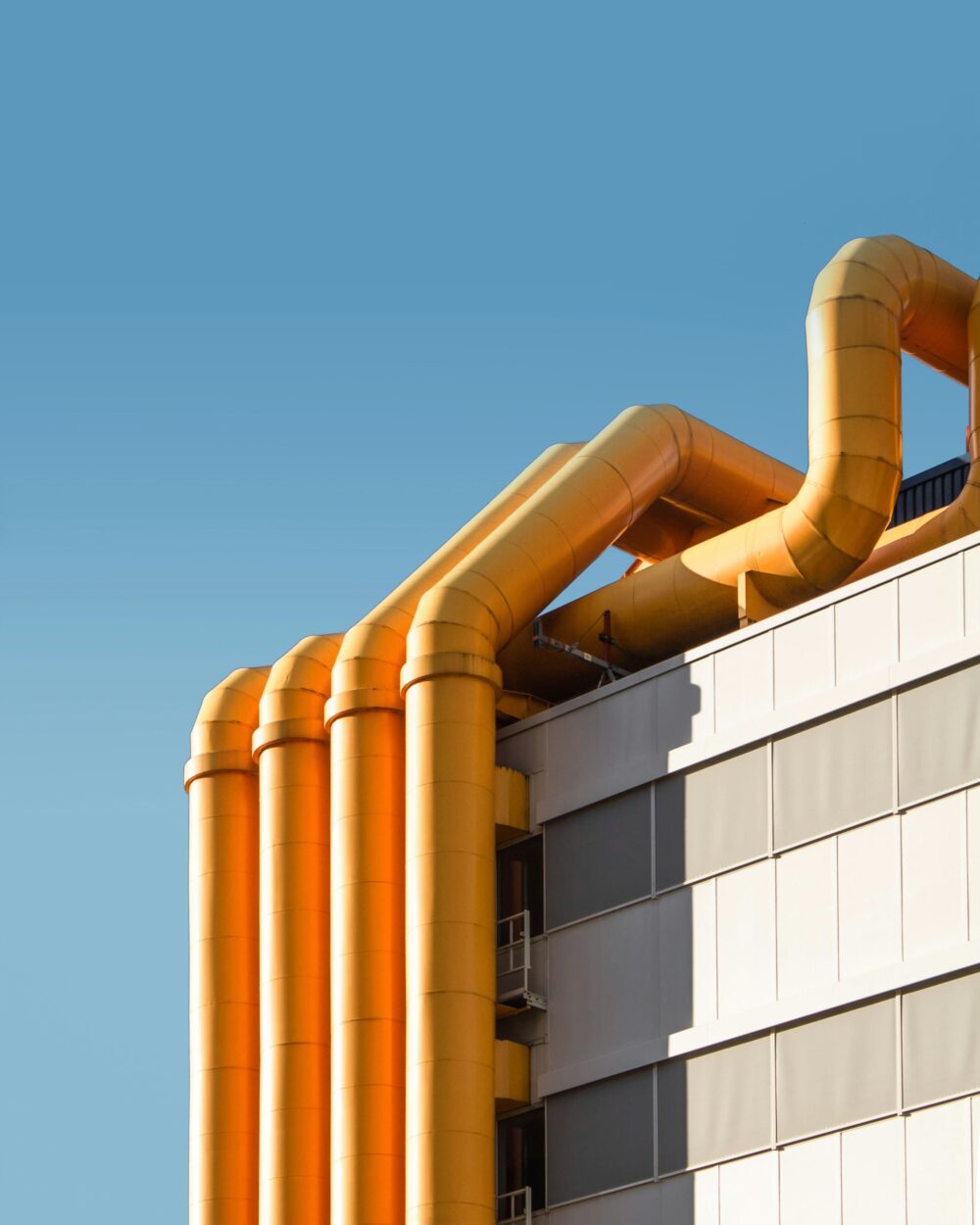 four orange pipes next to a building